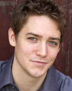 young male model smiling headshot blue shirt
